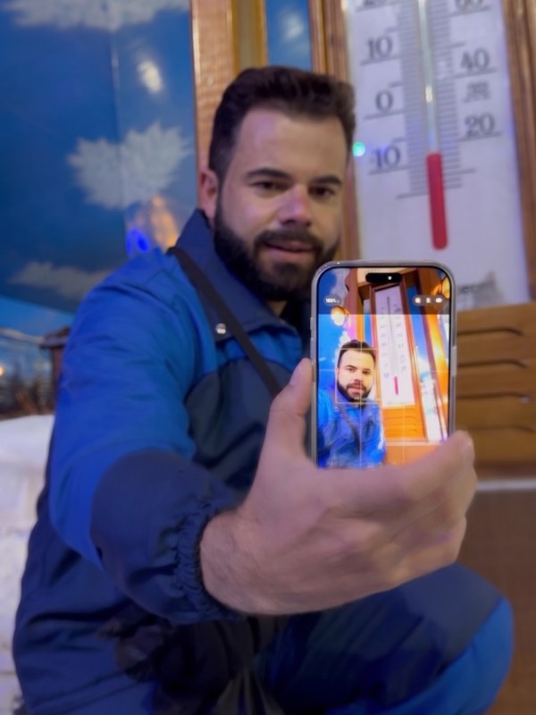 Dio Santos em contexto de trabalho, celular na mão, olhando para uma cena